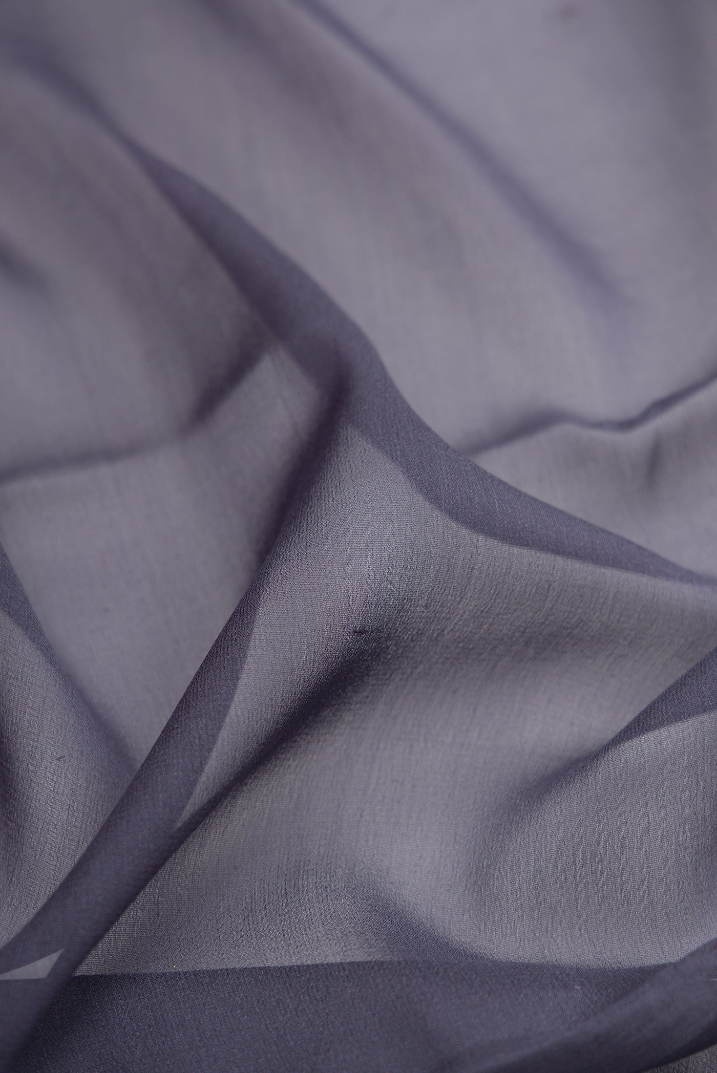 Close up of Grey Mysore Georgette Saree with Plain Body and Zari Border.  displaying folds