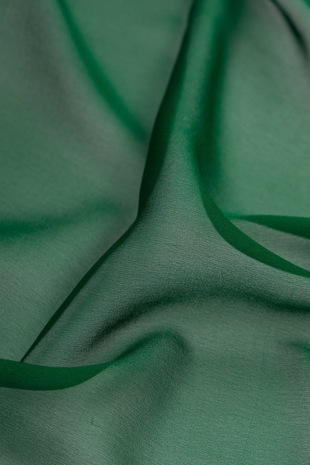 Close up of Bottle Green Mysore Georgette Saree with Plain Body and Zari Border.  displaying folds