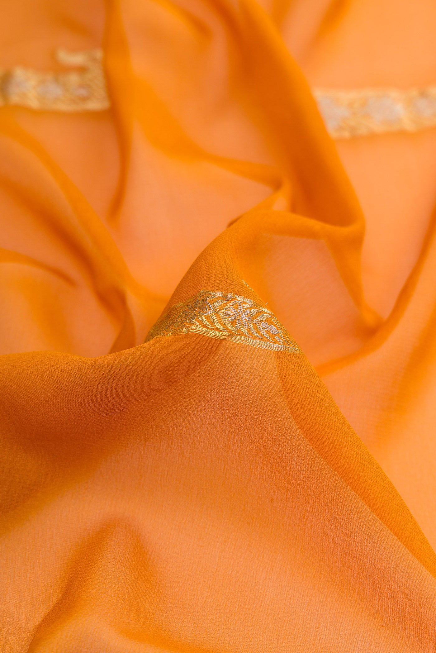 Close up of Mustard Dual Tone Mysore Georgette Saree with Zari Butta on the body and Zari Border.  displaying folds