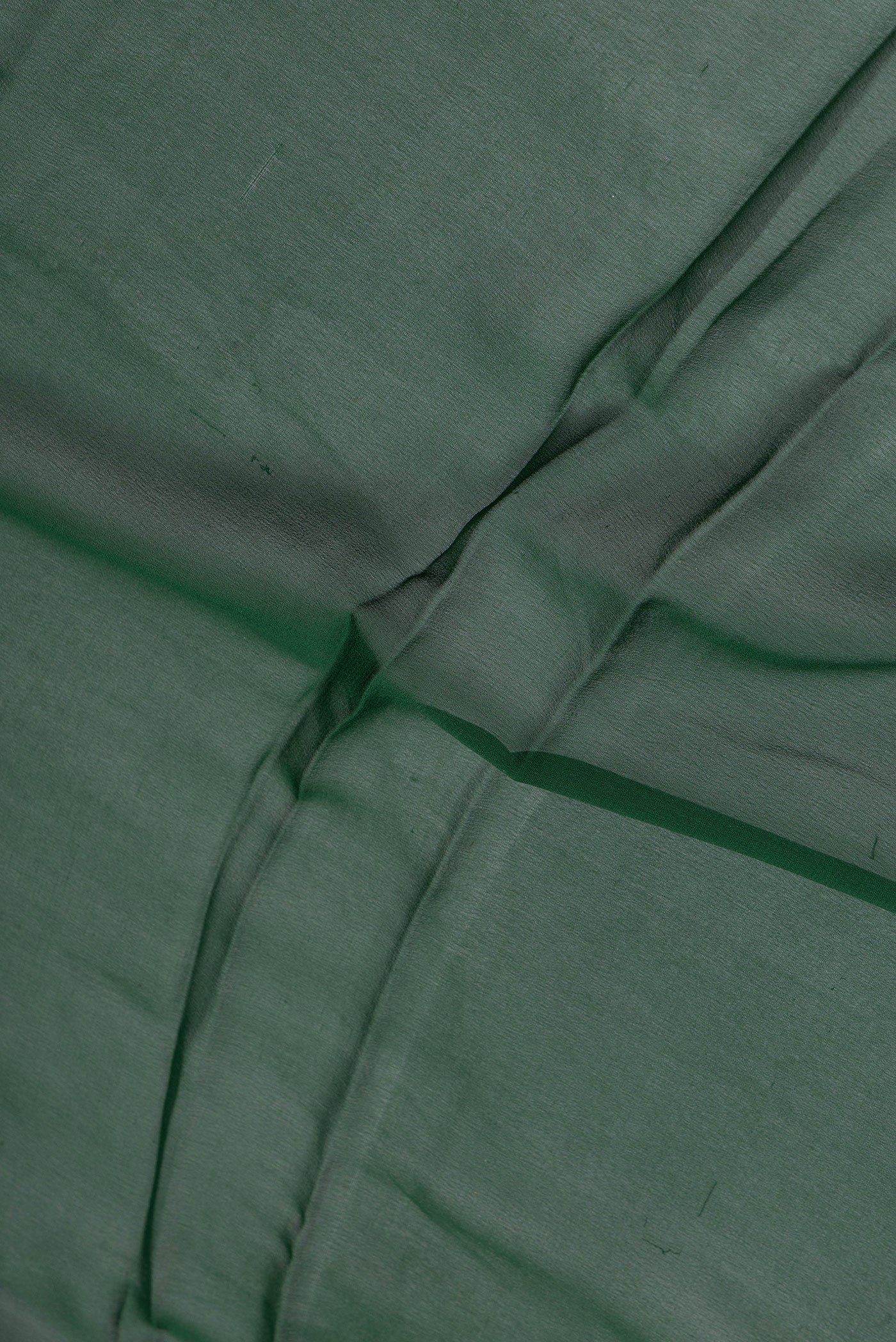 Close up of Bottle Green Mysore Georgette Saree with Plain Body and Zari Border.  displaying folds