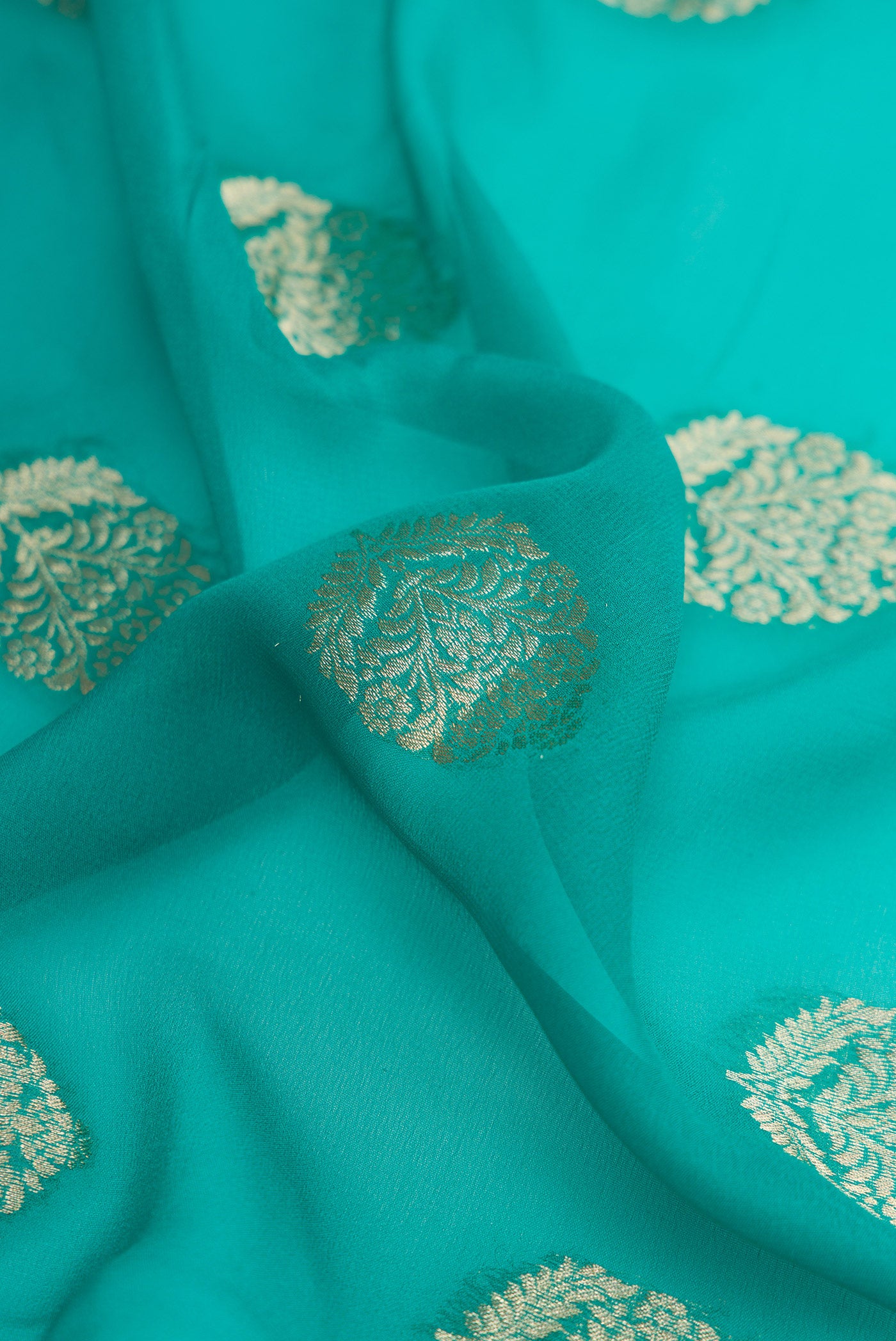 Close up of Peacock Blue Mysore Georgette Saree with Zari Butta on the body and Zari Border.  displaying folds