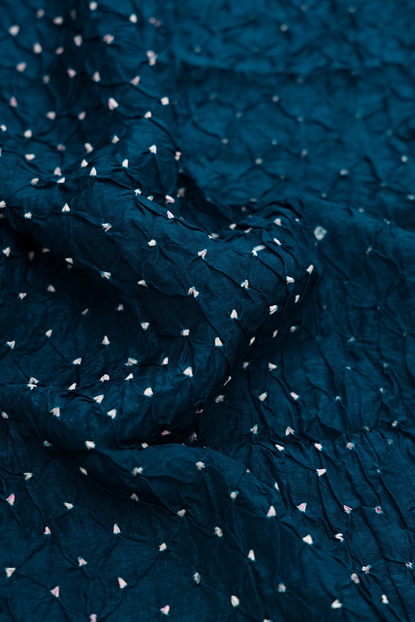 Close up of Peacock Blue Dual Tone Bandhani Silk Saree with Bandhani Print on the body and Zari Border.  displaying folds