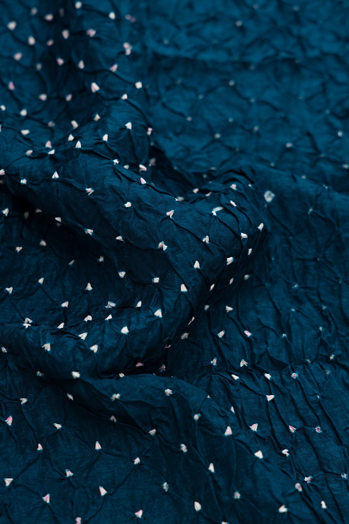 Close up of Peacock Blue Dual Tone Bandhani Silk Saree with Bandhani Print on the body and Zari Border.  displaying folds