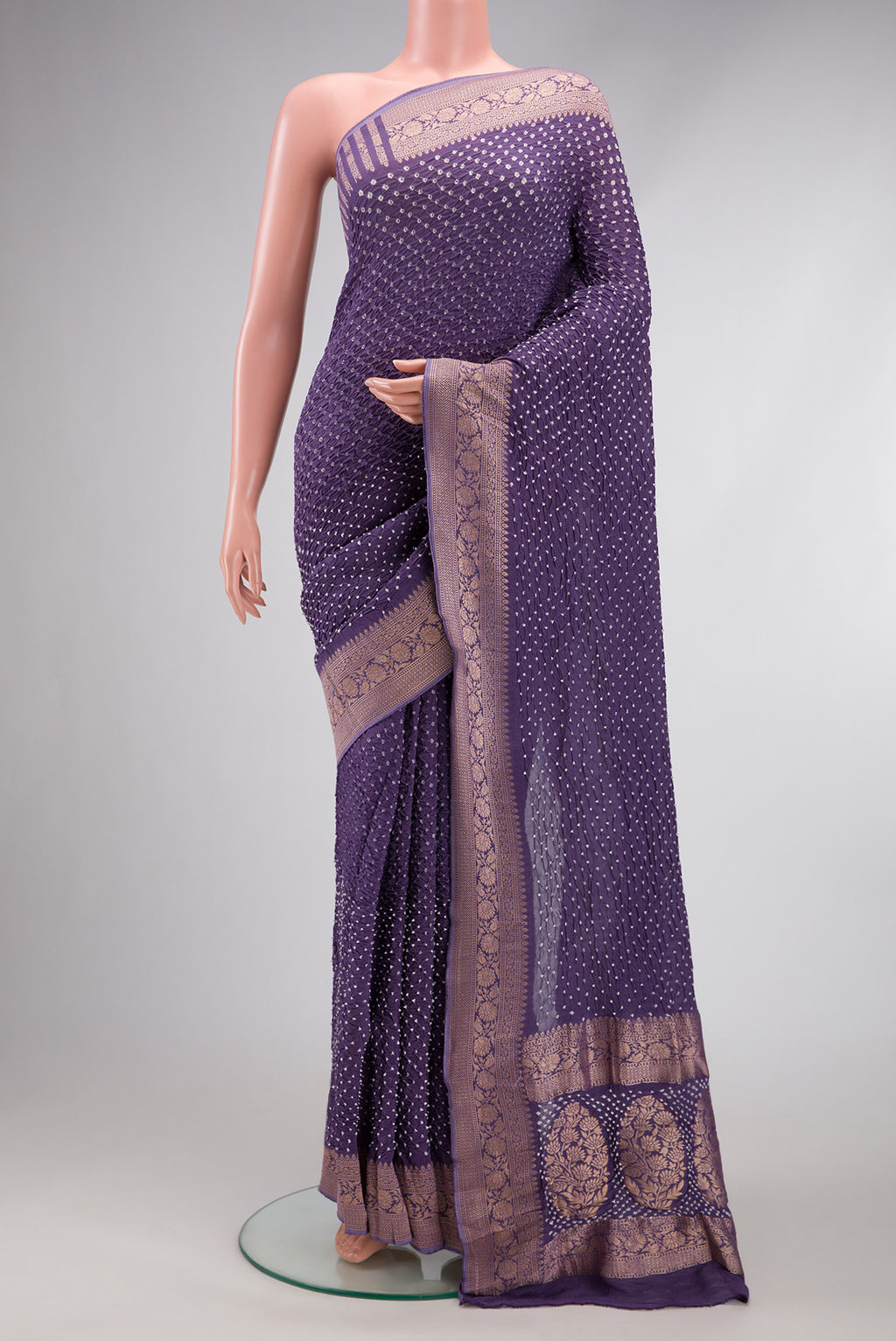 Lavender Bandhani Silk Saree with Bandhani Print on the body and Zari Border.  displayed on a mannequin