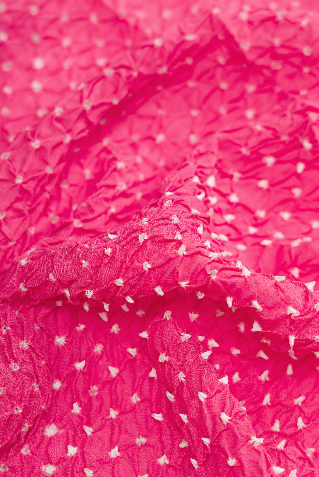 Close up of Pink Dual Tone Bandhani Silk Saree with Bandhani Print on the body and Zari Border.  displaying folds