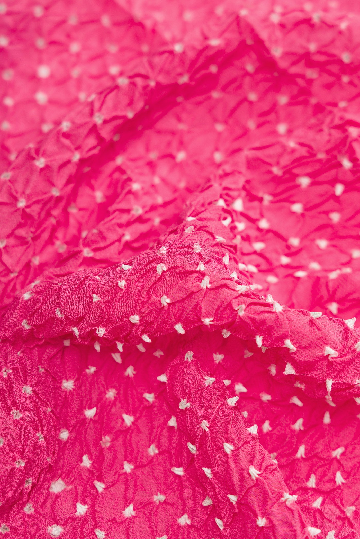 Close up of Pink Dual Tone Bandhani Silk Saree with Bandhani Print on the body and Zari Border.  displaying folds