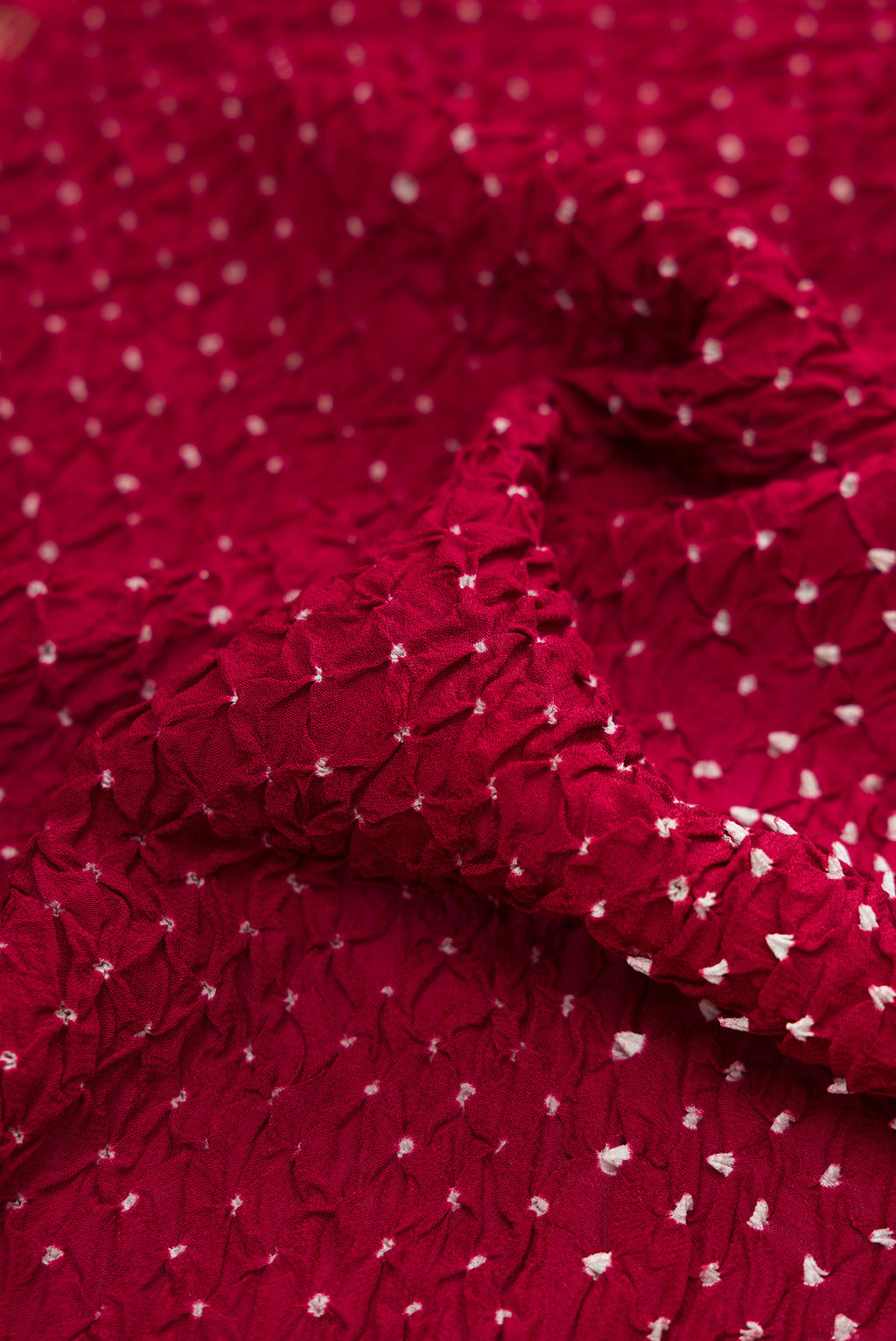 Close up of Maroon Bandhani Silk Saree with Bandhani Print on the body and Zari Border.  displaying folds