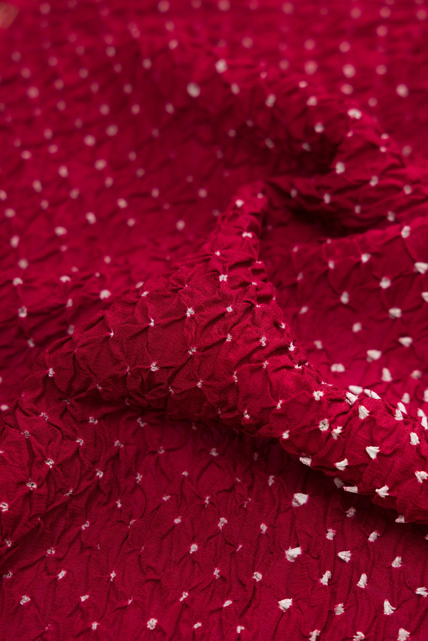 Close up of Maroon Bandhani Silk Saree with Bandhani Print on the body and Zari Border.  displaying folds