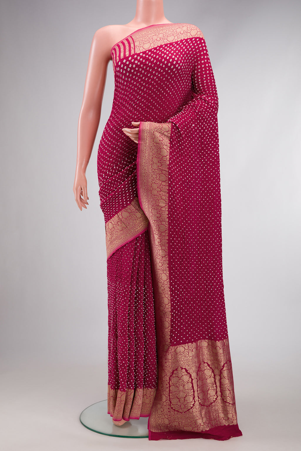 Magenta Dual Tone Bandhani Silk Saree with Bandhani Print on the body and Zari Border.  displayed on a mannequin