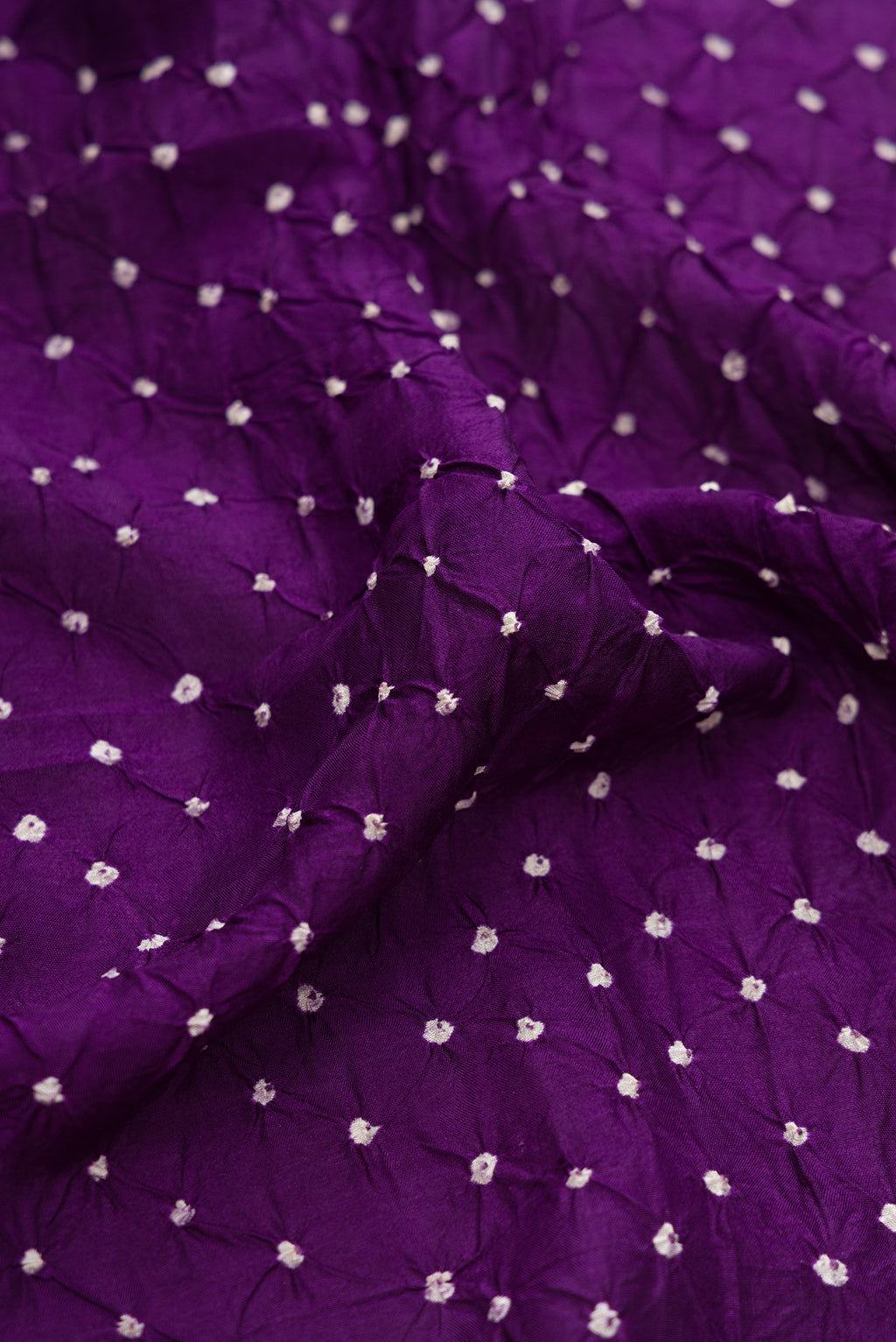 Close up of Violet Dual Tone Bandhani Silk Saree with Bandhani Print on the body and Paithani Border.  displaying folds