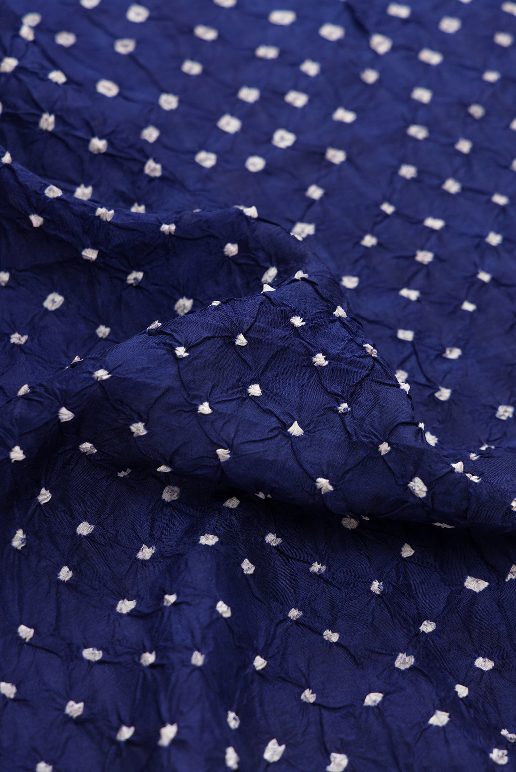 Close up of Navy Blue Dual Tone Bandhani Silk Saree with Bandhani Print on the body and Paithani Border.  displaying folds