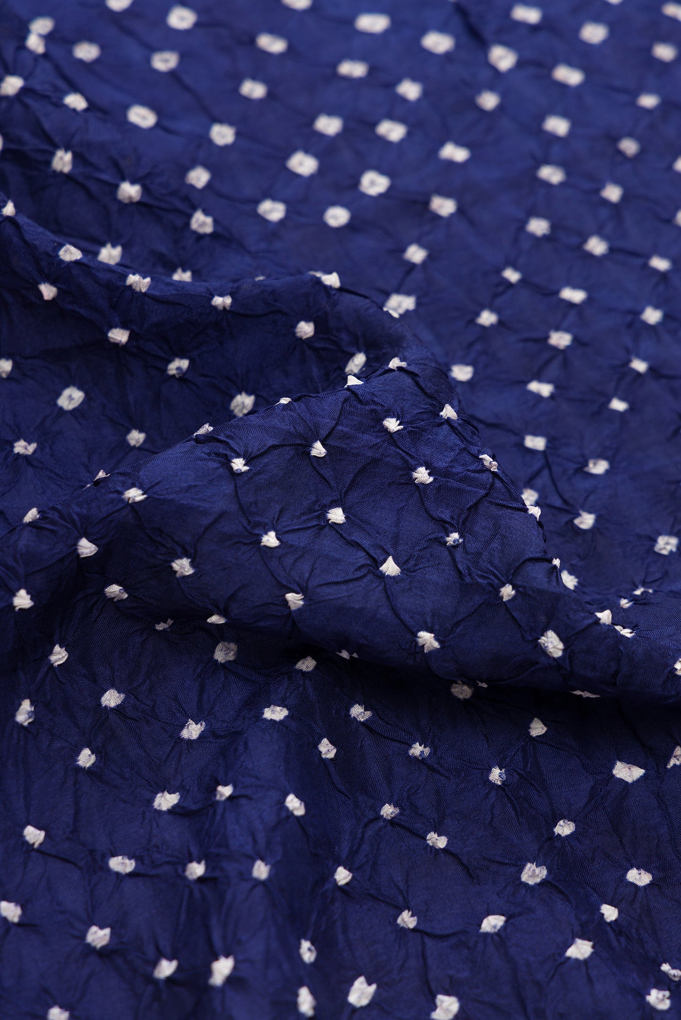 Close up of Navy Blue Dual Tone Bandhani Silk Saree with Bandhani Print on the body and Paithani Border.  displaying folds