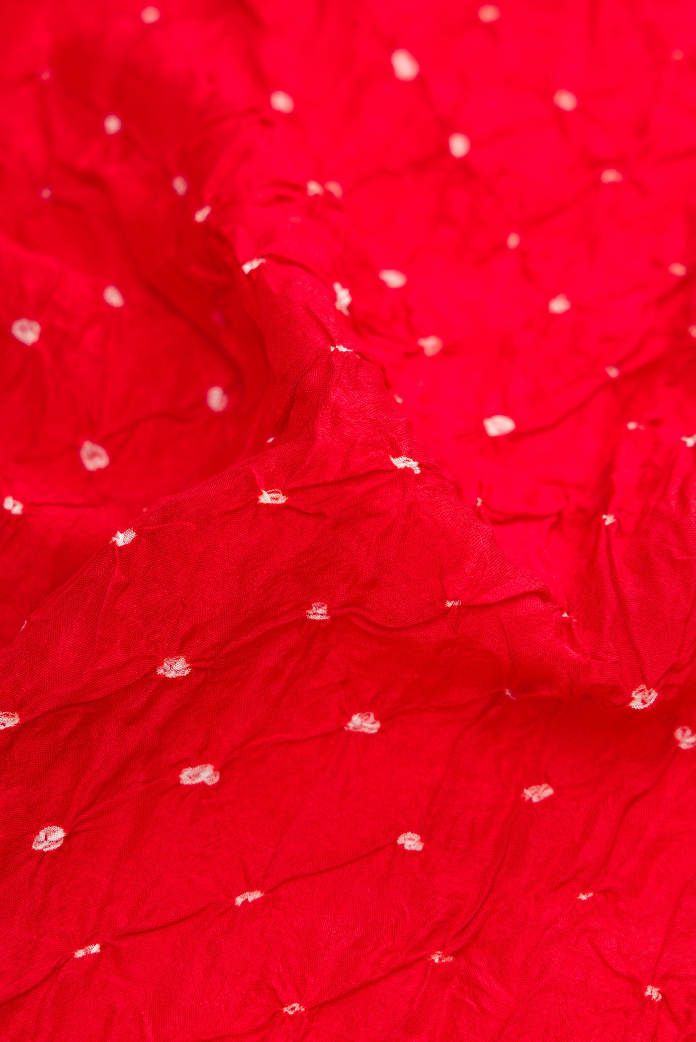 Close up of Red Bandhani Silk Saree with Bandhani Print on the body and Zari Border.  displaying folds