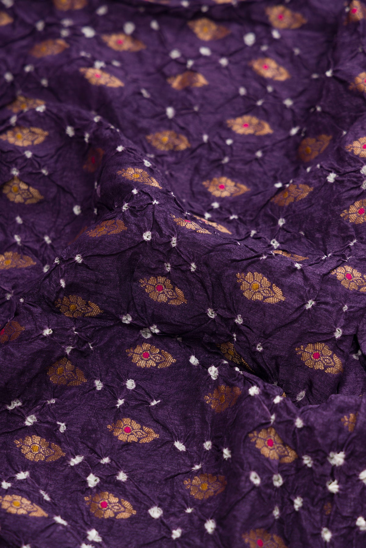 Close up of Purple Blended Bandhani Silk Saree with Bandhani Print on the body and Zari Border.  displaying folds
