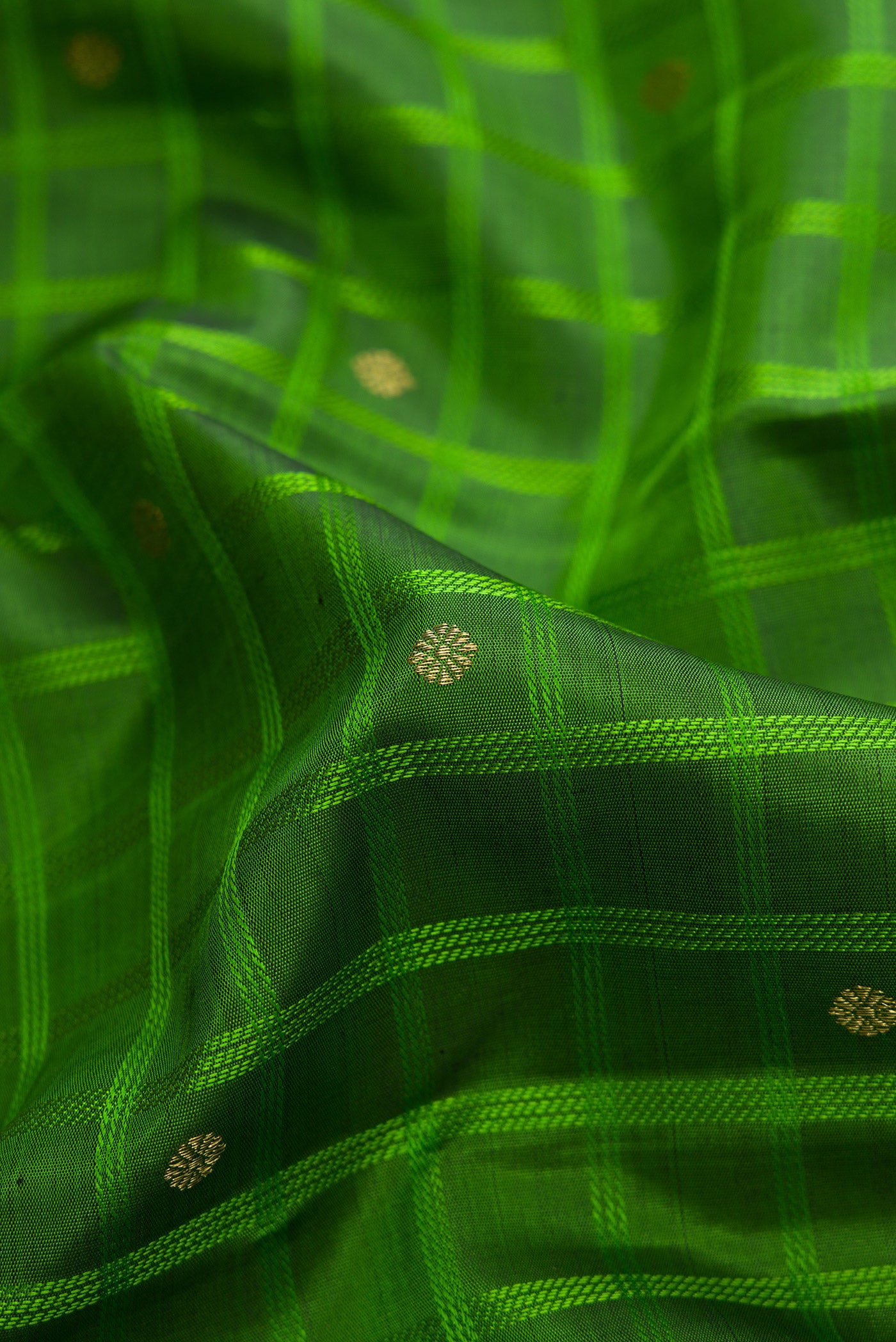 Close up of Pure Silk Pure Zari Green Dual Tone Kanchipuram Saree with Checked design on the body and Ganga Jamuna Border.  displaying folds