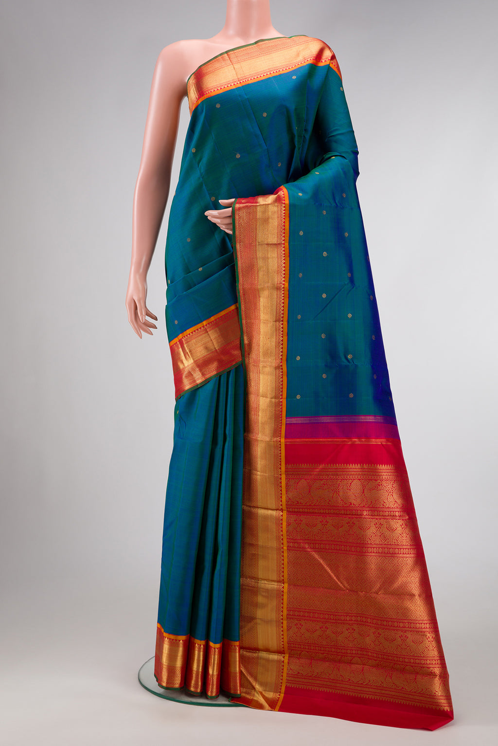 Pure Silk Pure Zari Peacock Blue Dual Tone Kanjivaram Saree with Zari Butta on the body and Zari Border.  displayed on a mannequin