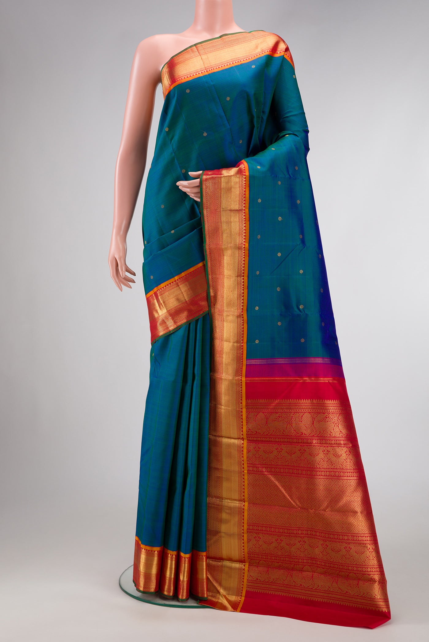 Pure Silk Pure Zari Peacock Blue Dual Tone Kanjivaram Saree with Zari Butta on the body and Zari Border.  displayed on a mannequin