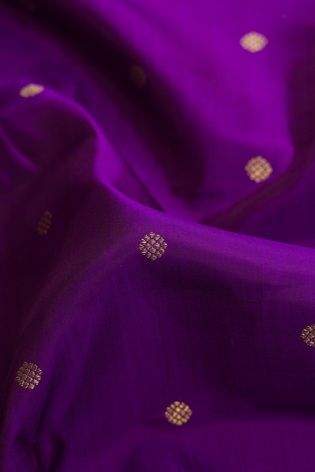 Close up of Violet Dual Tone Kanjivaram Silk Saree with Zari Butta on the body and Zari Border.  displaying folds