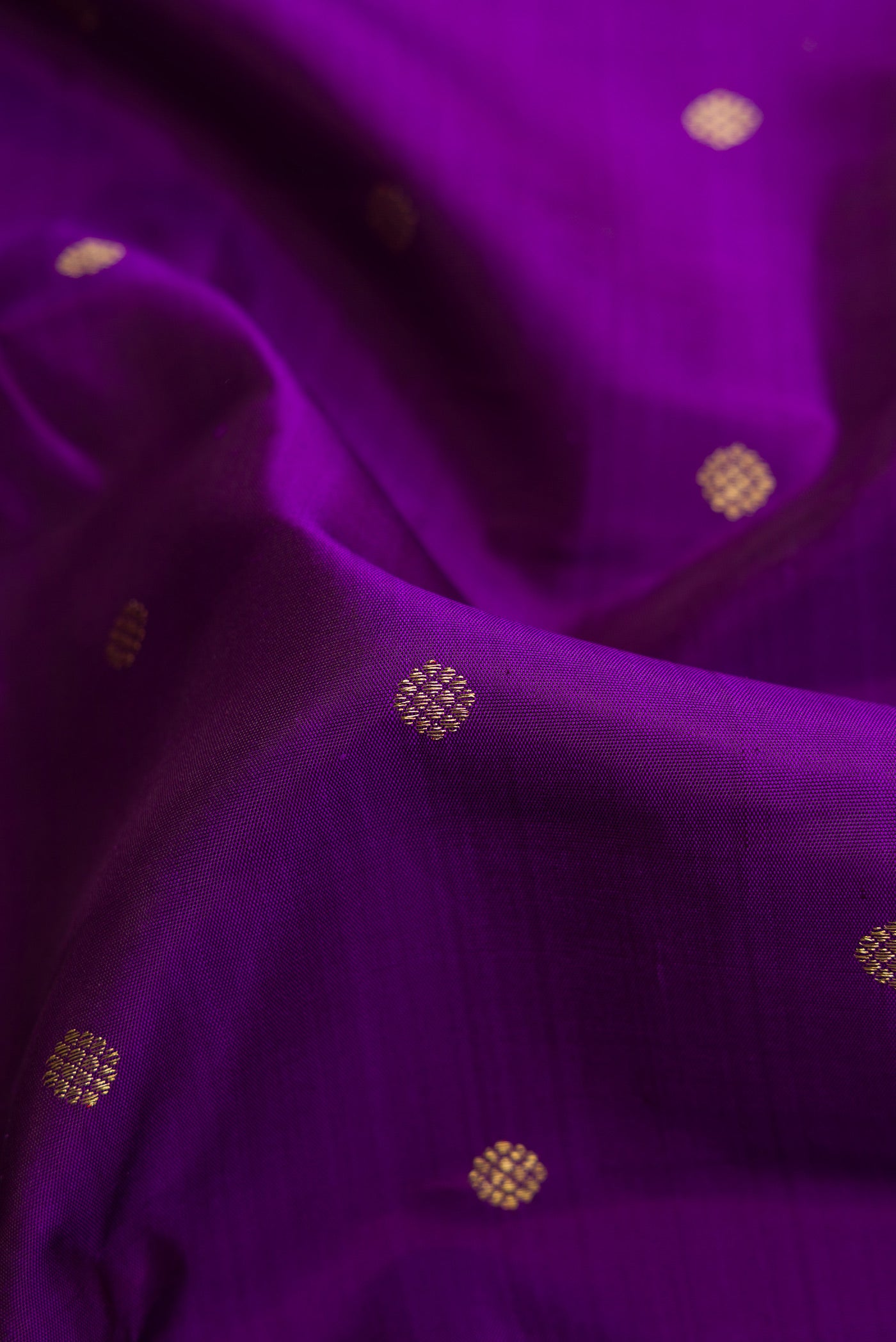 Close up of Violet Dual Tone Kanjivaram Silk Saree with Zari Butta on the body and Zari Border.  displaying folds