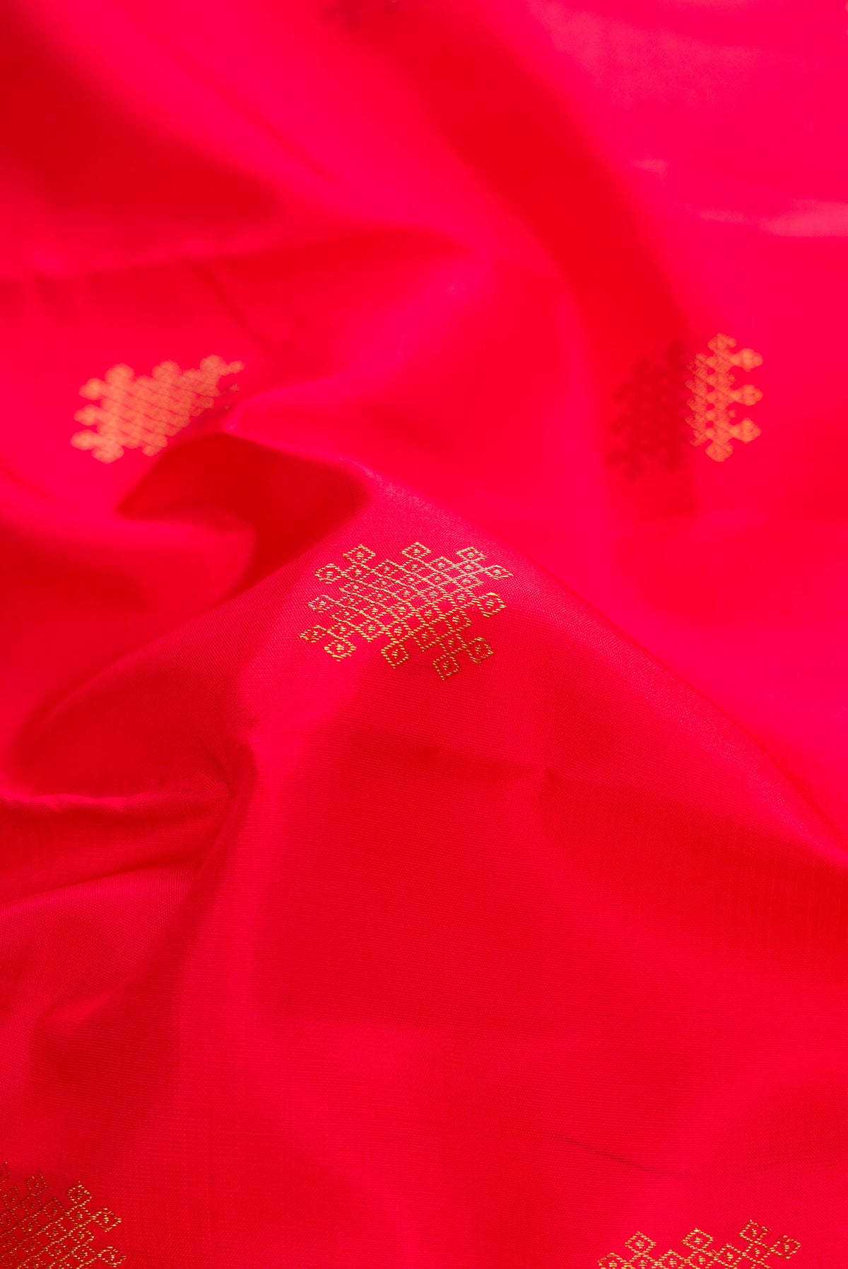 Close up of Red Dual Tone Kanchipuram Silk Saree with Zari Butta on the body and Without Border.  displaying folds