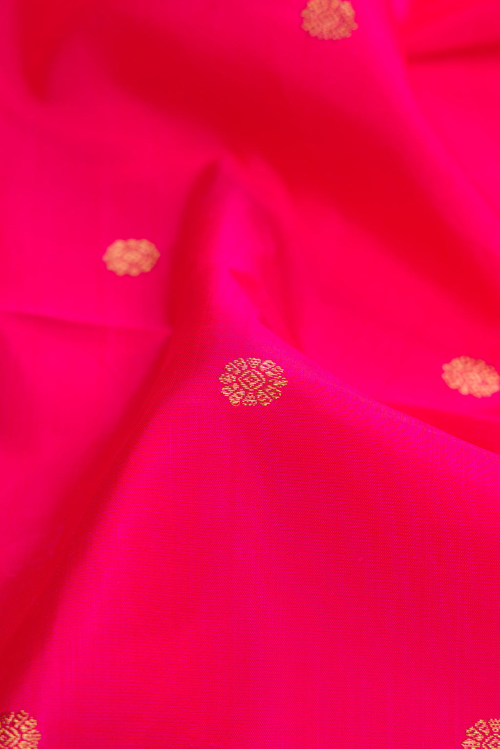Close up of Pure Silk Pure Zari Pink Dual Tone Kanjivaram Saree with Zari Butta on the body and Zari Border.  displaying folds