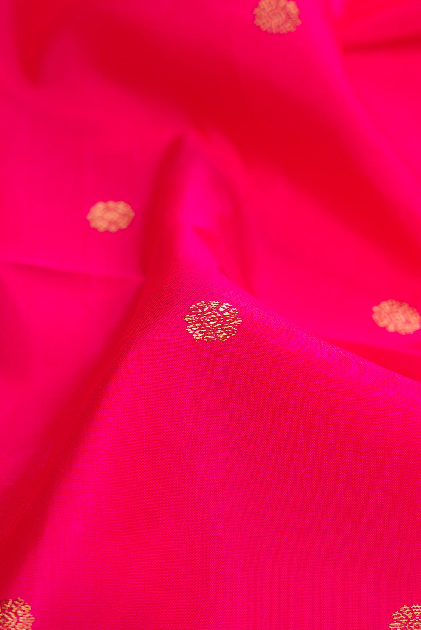 Close up of Pure Silk Pure Zari Pink Dual Tone Kanjivaram Saree with Zari Butta on the body and Zari Border.  displaying folds