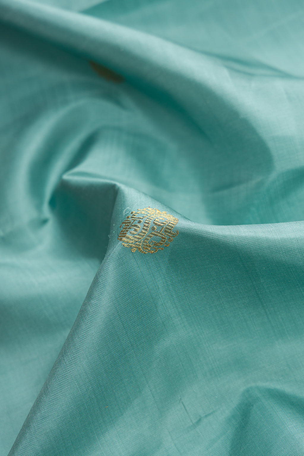 Close up of Pure Silk Pure Zari Sky Blue Dual Tone Kanjivaram Saree with Zari Butta on the body and Zari Border.  displaying folds