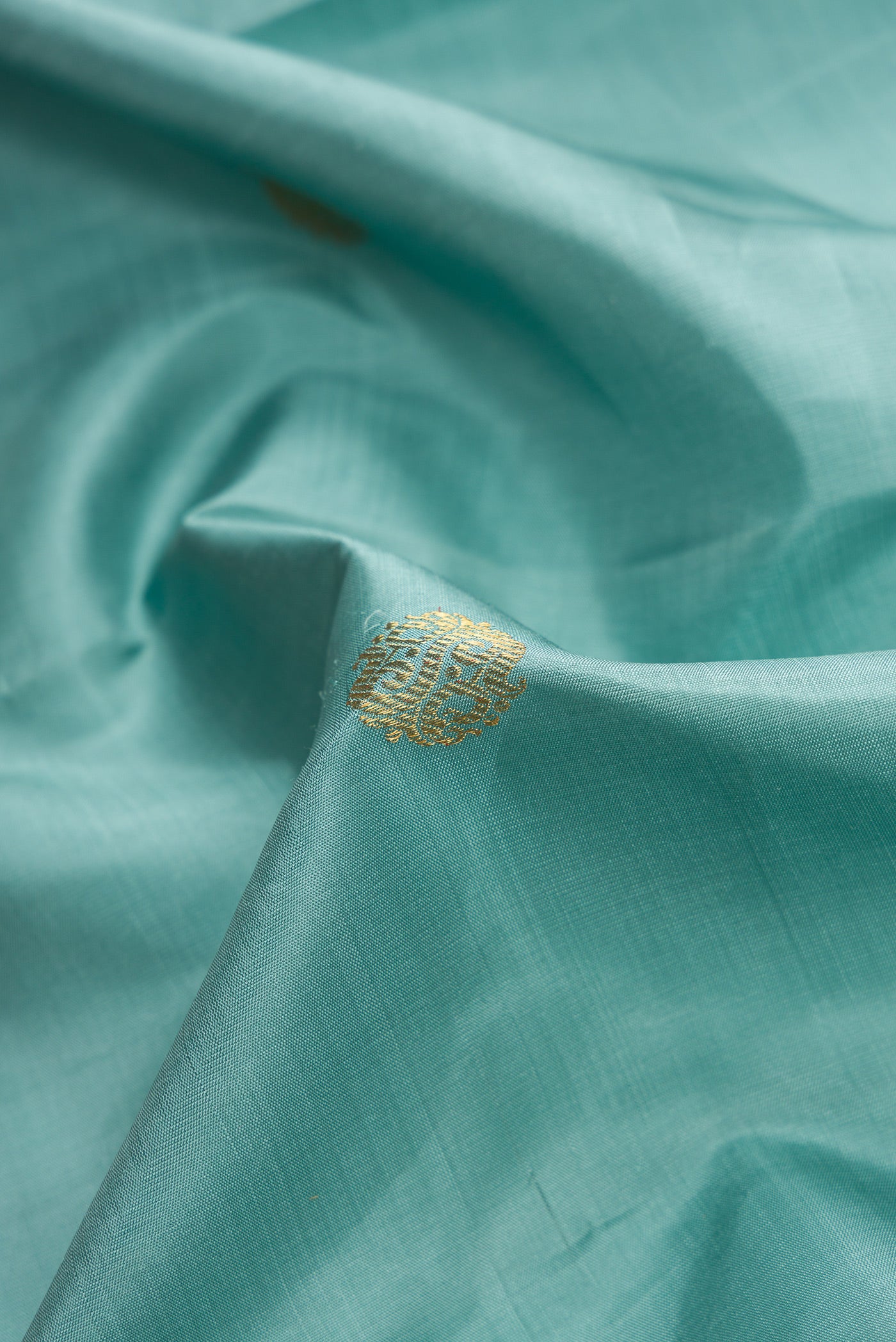 Close up of Pure Silk Pure Zari Sky Blue Dual Tone Kanjivaram Saree with Zari Butta on the body and Zari Border.  displaying folds