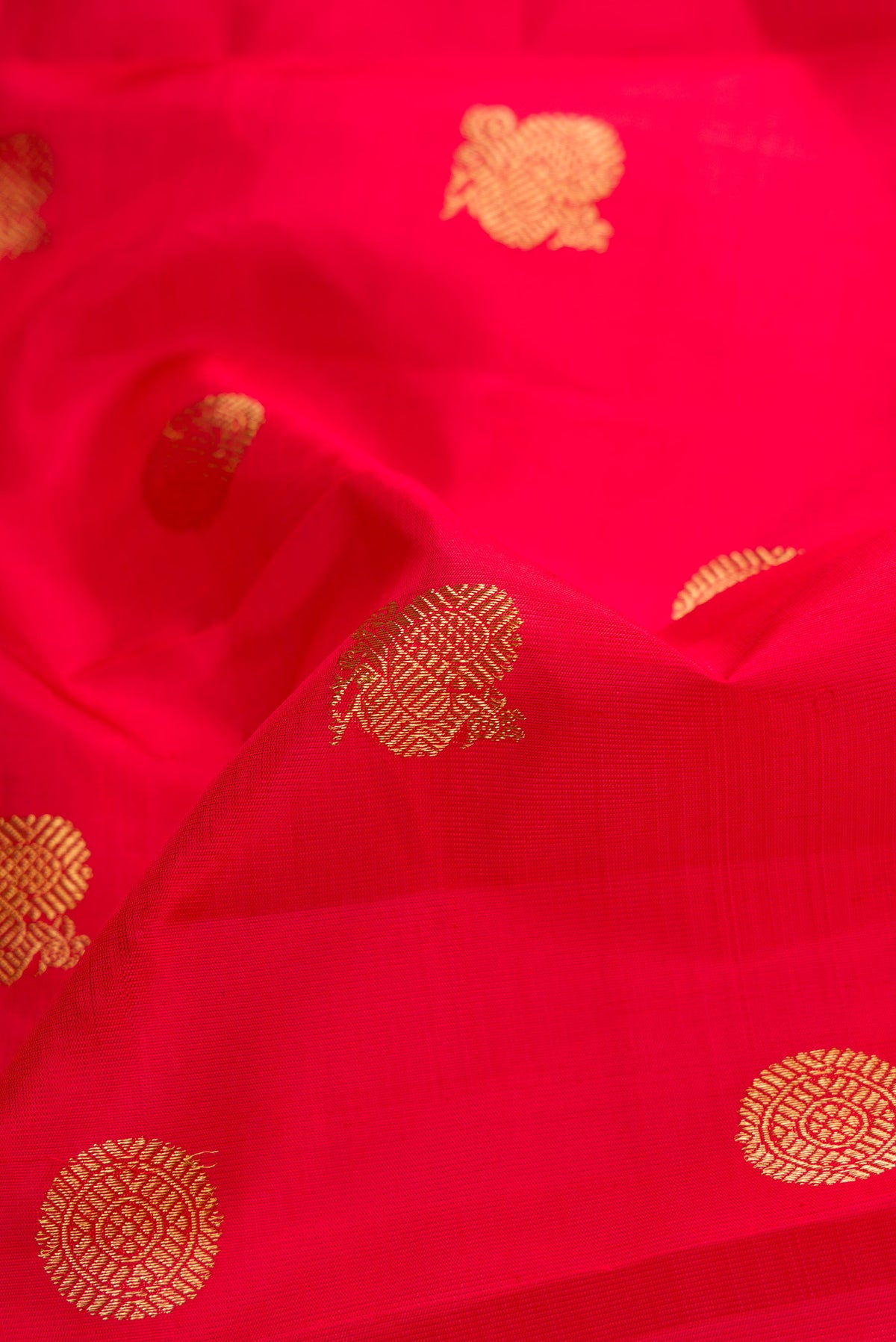 Close up of Red Dual Tone Kanjivaram Silk Saree with Zari Butta on the body and Zari Border.  displaying folds