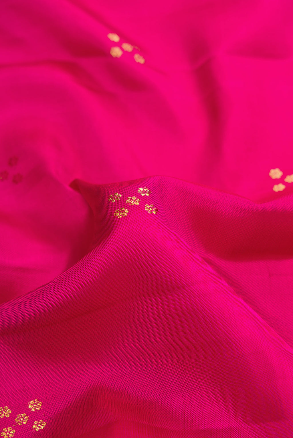 Close up of Pure Silk Pure Zari Pink Dual Tone Kanchipuram Saree with Zari Butta on the body and Fancy Border.  displaying folds