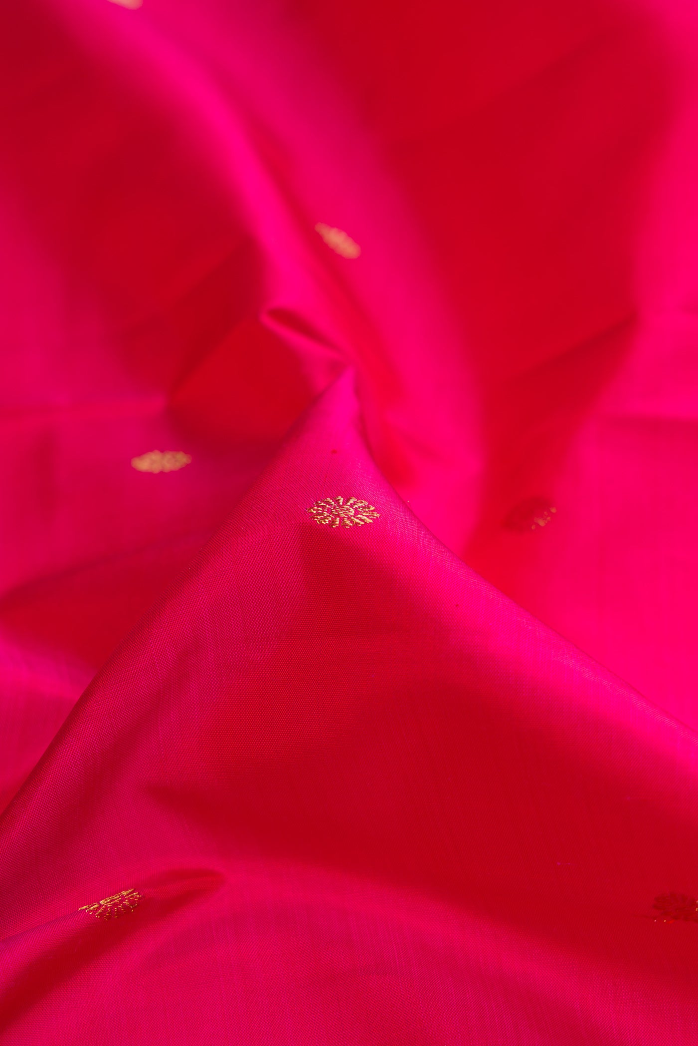 Close up of Pure Silk Pure Zari Pink Dual Tone Kanjivaram Saree with Zari Butta on the body and Zari Border.  displaying folds