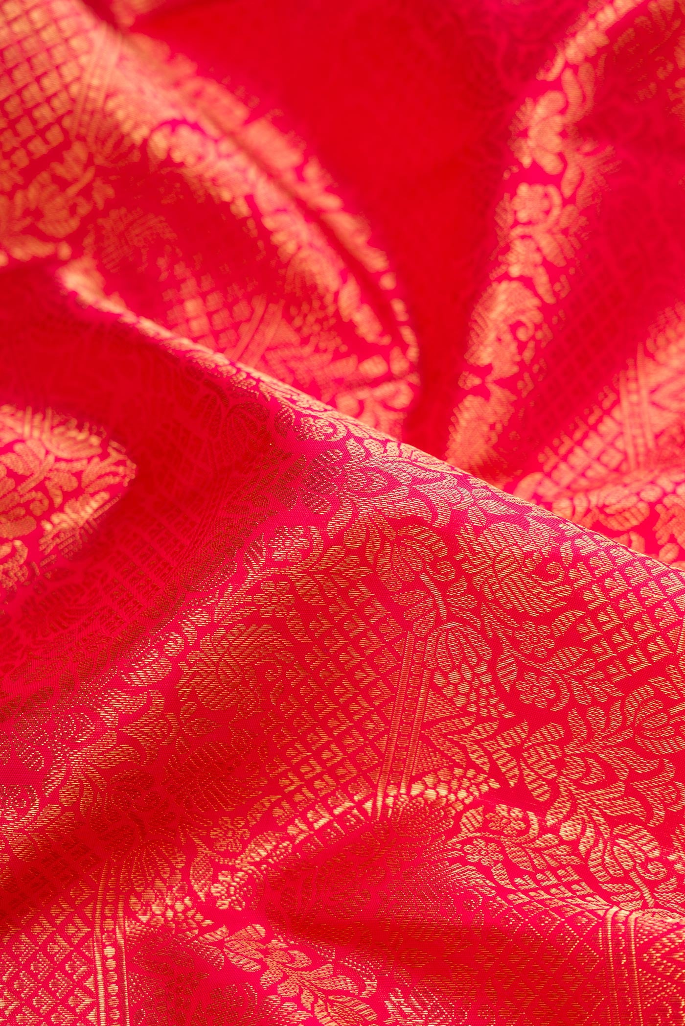Close up of Pure Silk Pure Zari Red Dual Tone Kanjivaram Saree with Zari Brocade on the body and Zari Border.  displaying folds