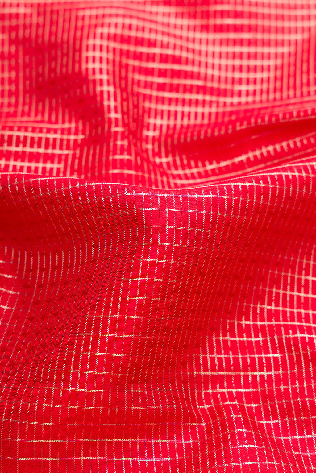 Close up of Red Dual Tone Kanchipuram Silk Saree with Checked design on the body and Zari Border.  displaying folds