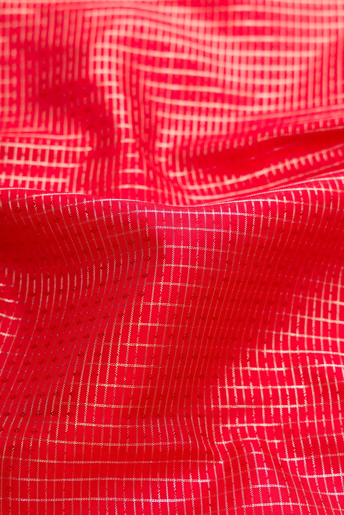 Close up of Red Dual Tone Kanchipuram Silk Saree with Checked design on the body and Zari Border.  displaying folds