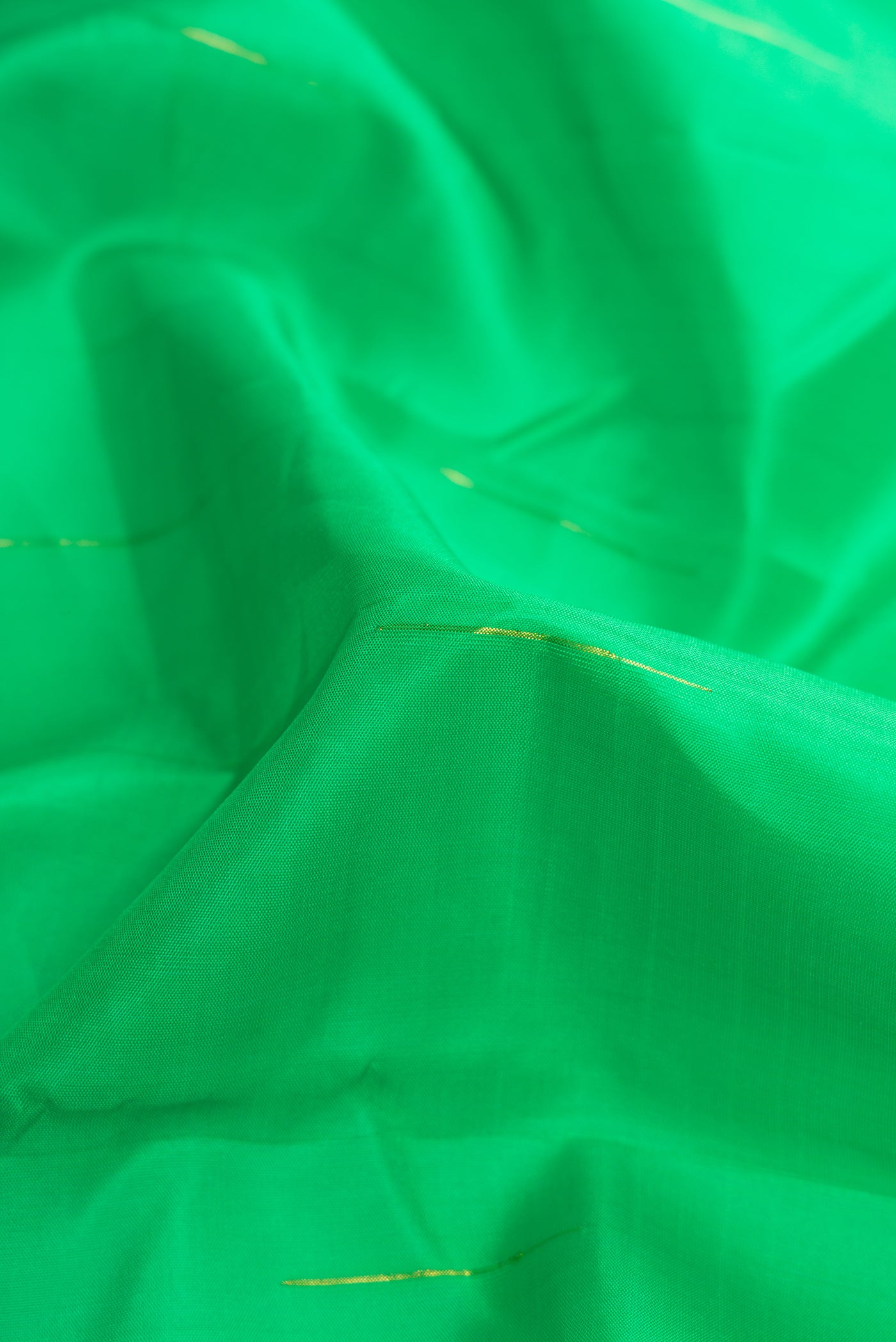 Close up of Parrot Green Dual Tone Kanjivaram Silk Saree with Zari Butta on the body and Zari Border.  displaying folds