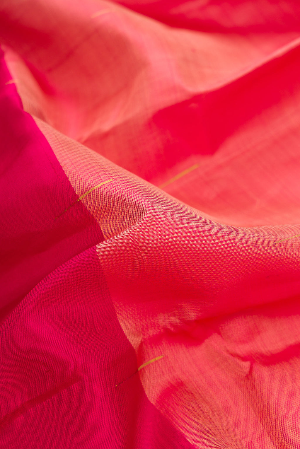 Close up of Peach and Dark Pink Color Kanjivaram Silk Saree with Half And Half on the body and Without Border.  displaying folds