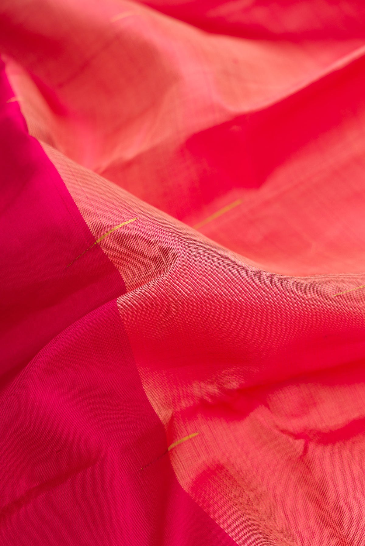 Close up of Peach and Dark Pink Color Kanjivaram Silk Saree with Half And Half on the body and Without Border.  displaying folds
