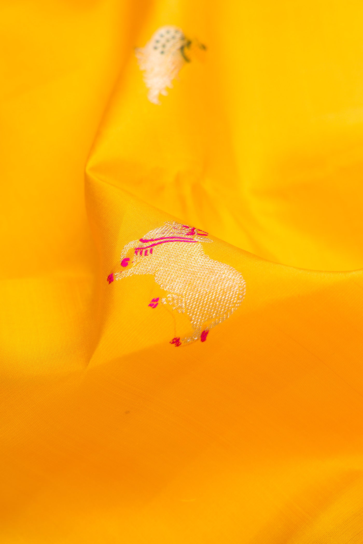 Close up of Yellow Dual Tone Kanjivaram Silk Saree with Zari And Thread Butta on the body and Thin Zari Line.  displaying folds