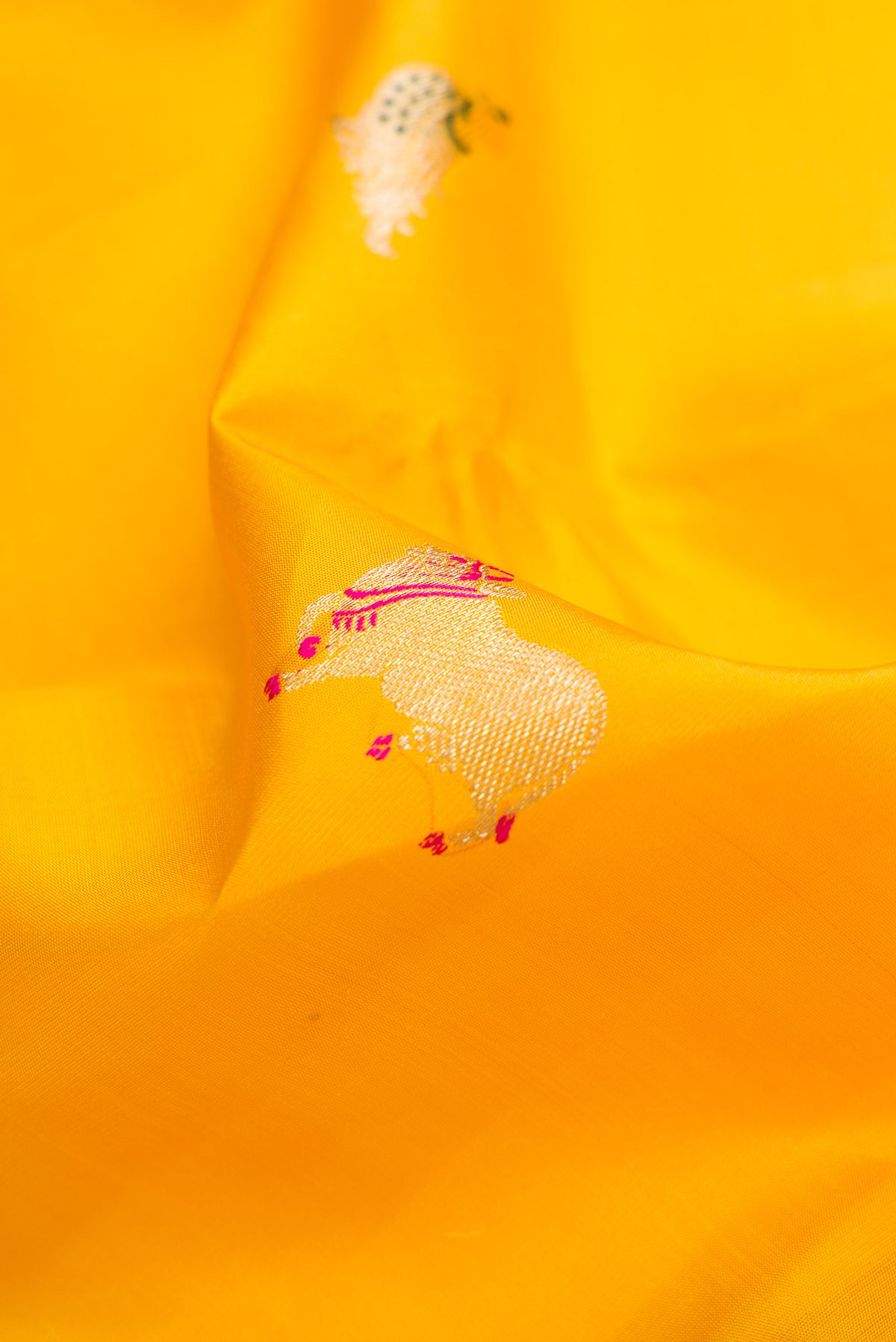 Close up of Yellow Dual Tone Kanjivaram Silk Saree with Zari And Thread Butta on the body and Thin Zari Line.  displaying folds
