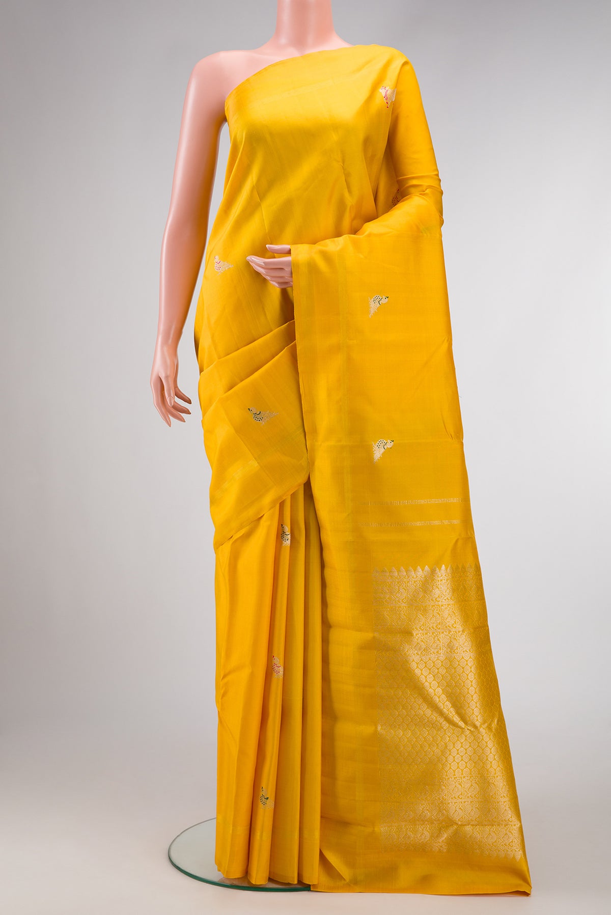 Yellow Dual Tone Kanjivaram Silk Saree with Zari And Thread Butta on the body and Thin Zari Line.  displayed on a mannequin
