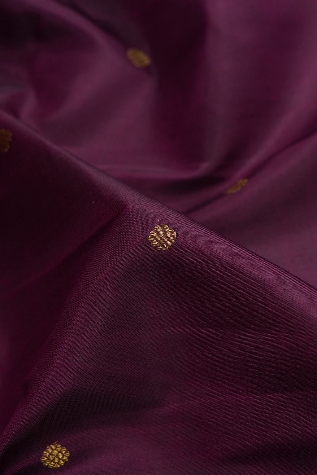 Close up of Burgundy Dual Tone Kanchipuram Silk Saree with Zari Butta on the body and Fancy Border.  displaying folds