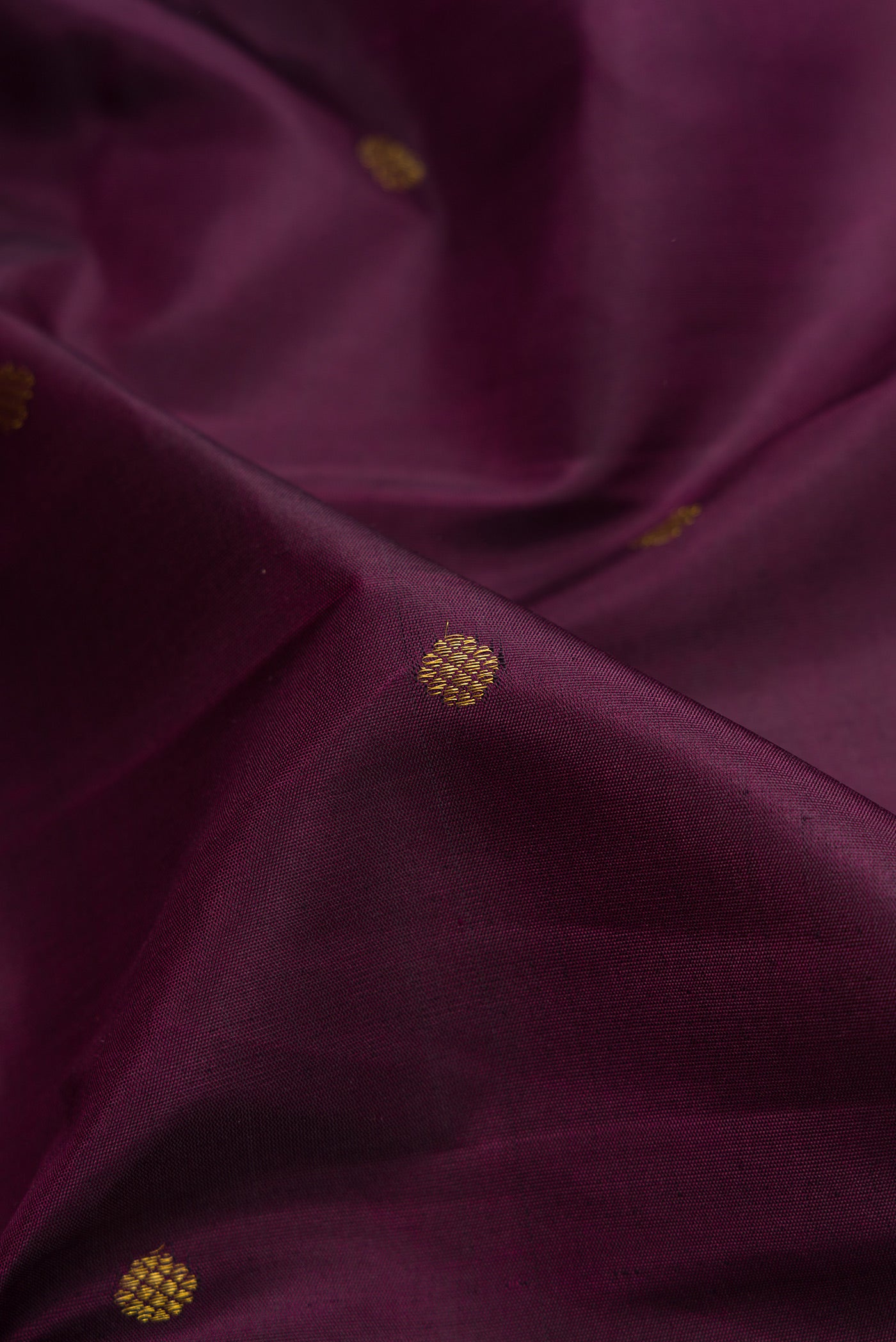Close up of Burgundy Dual Tone Kanchipuram Silk Saree with Zari Butta on the body and Fancy Border.  displaying folds