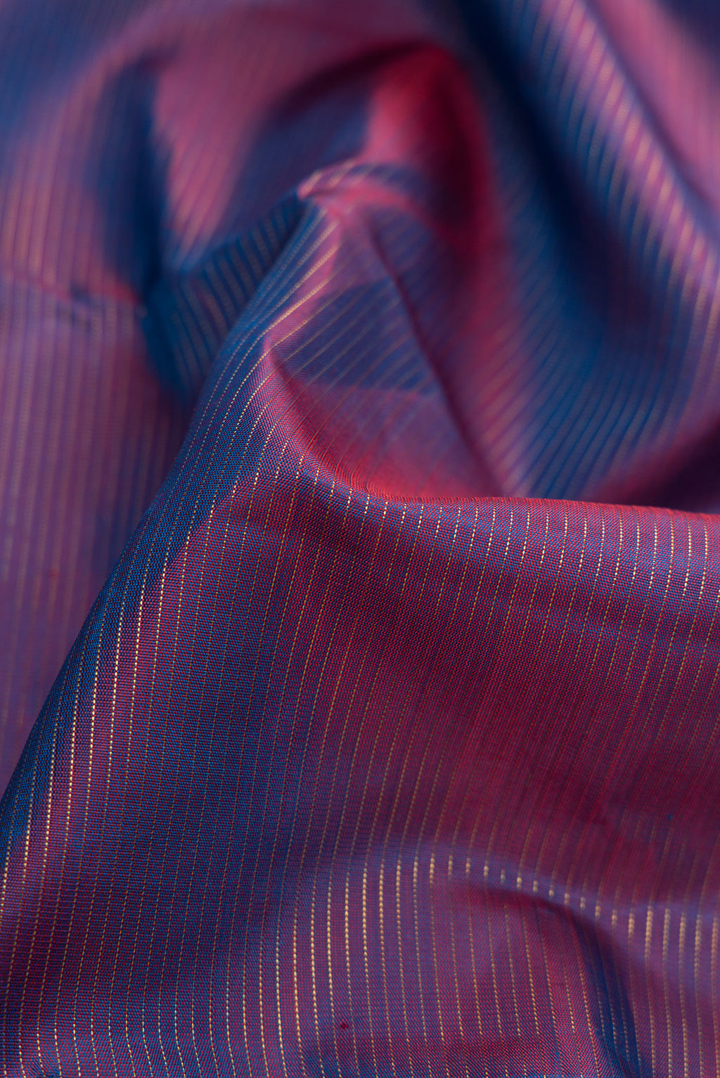 Close up of Pure Silk Pure Zari Purple Dual Tone Kanjivaram Saree with Stripes on the body and Zari Border.  displaying folds