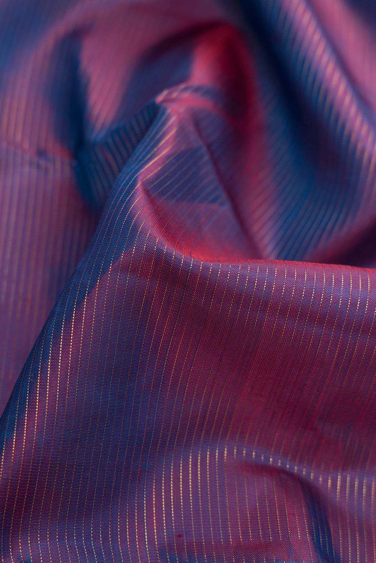 Close up of Pure Silk Pure Zari Purple Dual Tone Kanjivaram Saree with Stripes on the body and Zari Border.  displaying folds