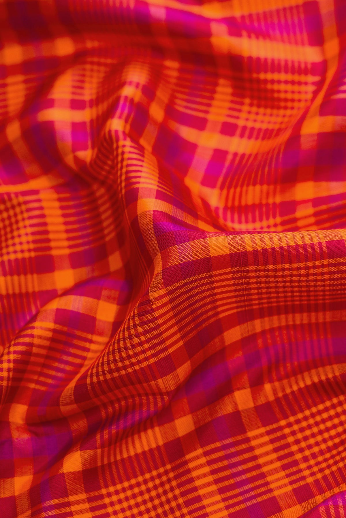 Close up of Pure Silk Pure Zari Orange Dual Tone Kanjivaram Saree with Checked design on the body and Zari Border.  displaying folds
