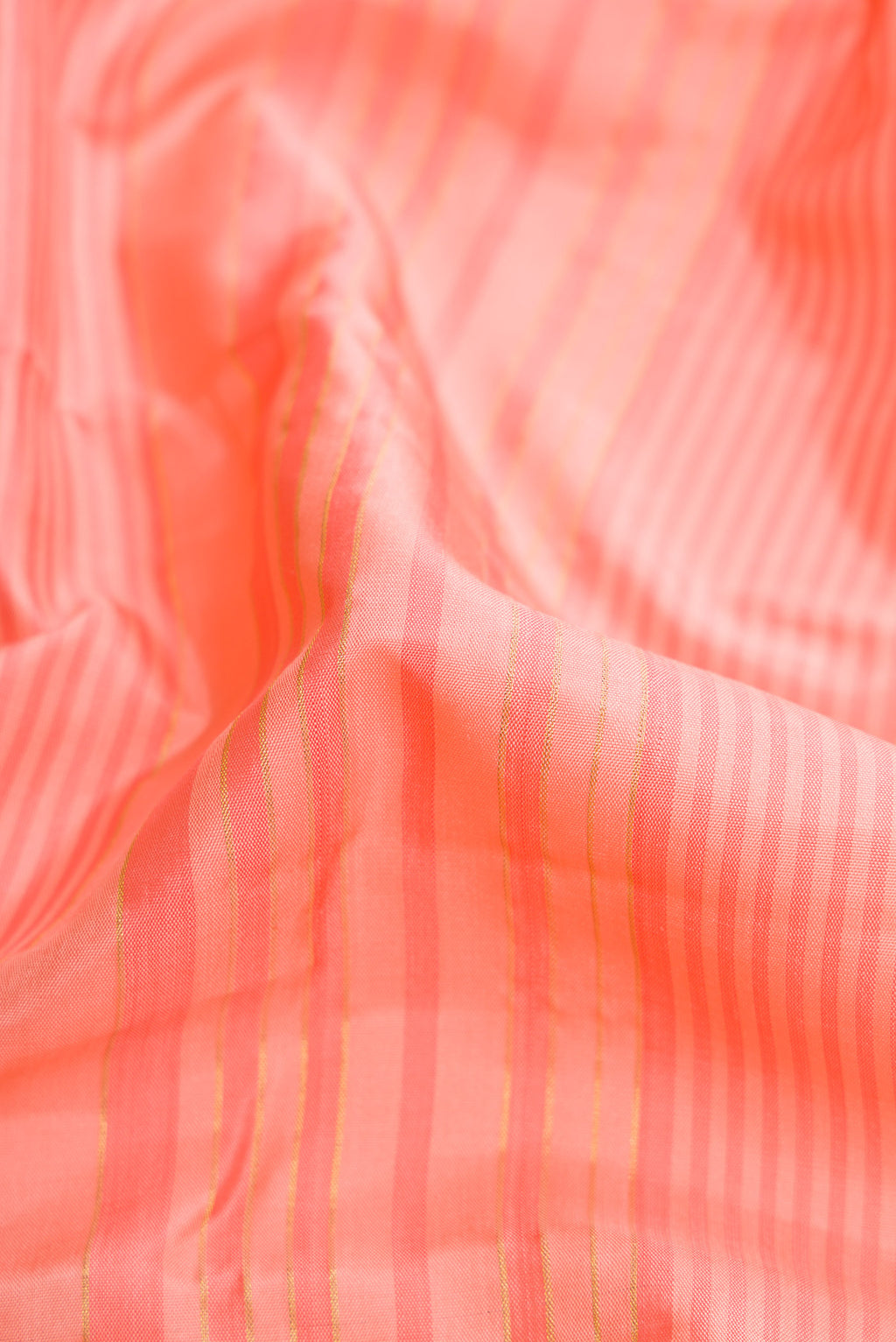 Close up of Peach Dual Tone Kanjivaram Silk Saree with Stripes on the body and Zari Border.  displaying folds