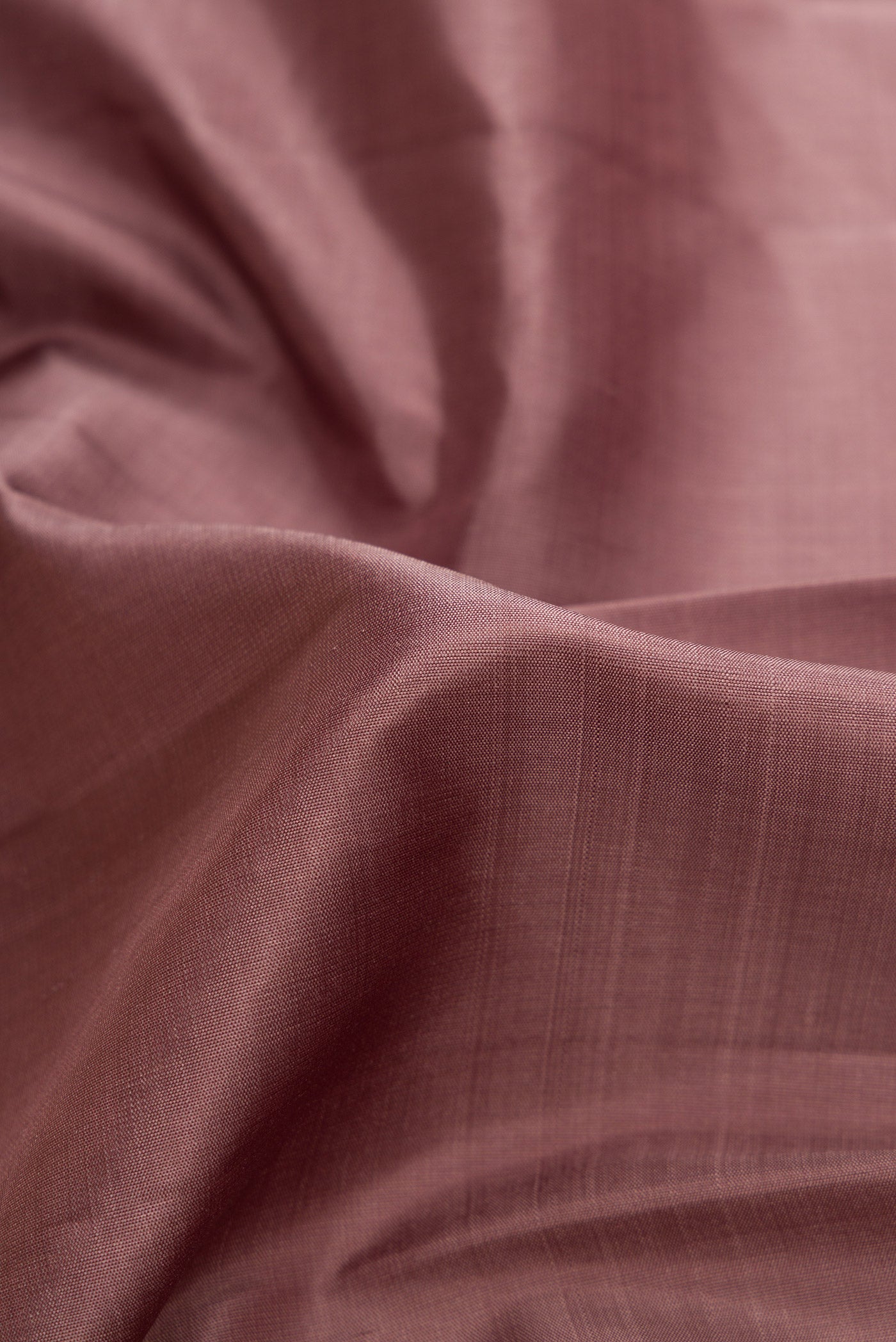 Close up of Bronze Dual Tone Kanjivaram Silk Saree with Plain Body and Zari Border.  displaying folds