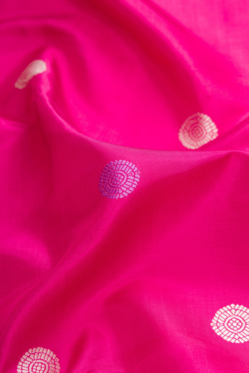 Close up of Pink Dual Tone Kanjivaram Silk Saree with Thread Butta on the body and Zari Border.  displaying folds