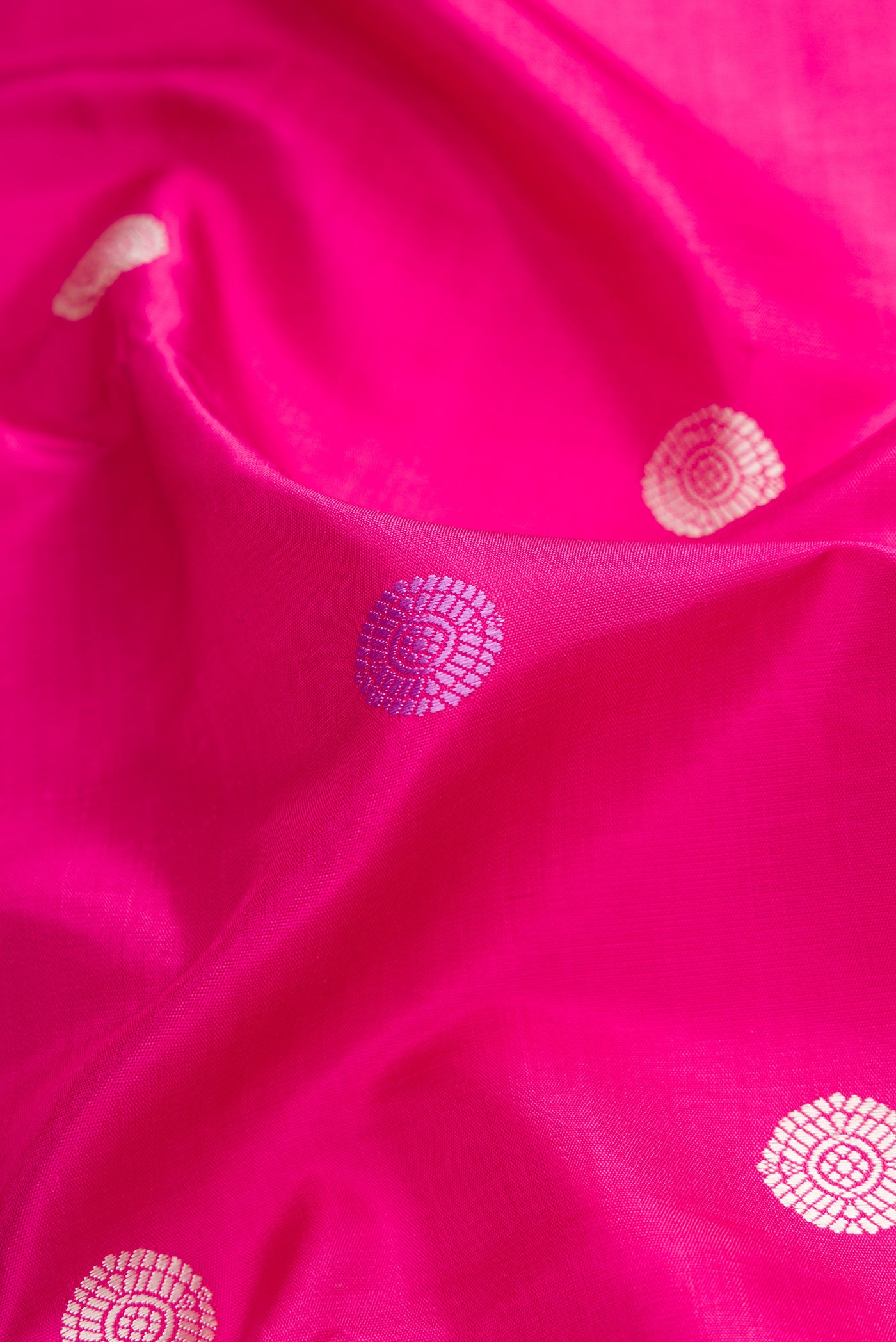 Close up of Pink Dual Tone Kanjivaram Silk Saree with Thread Butta on the body and Zari Border.  displaying folds