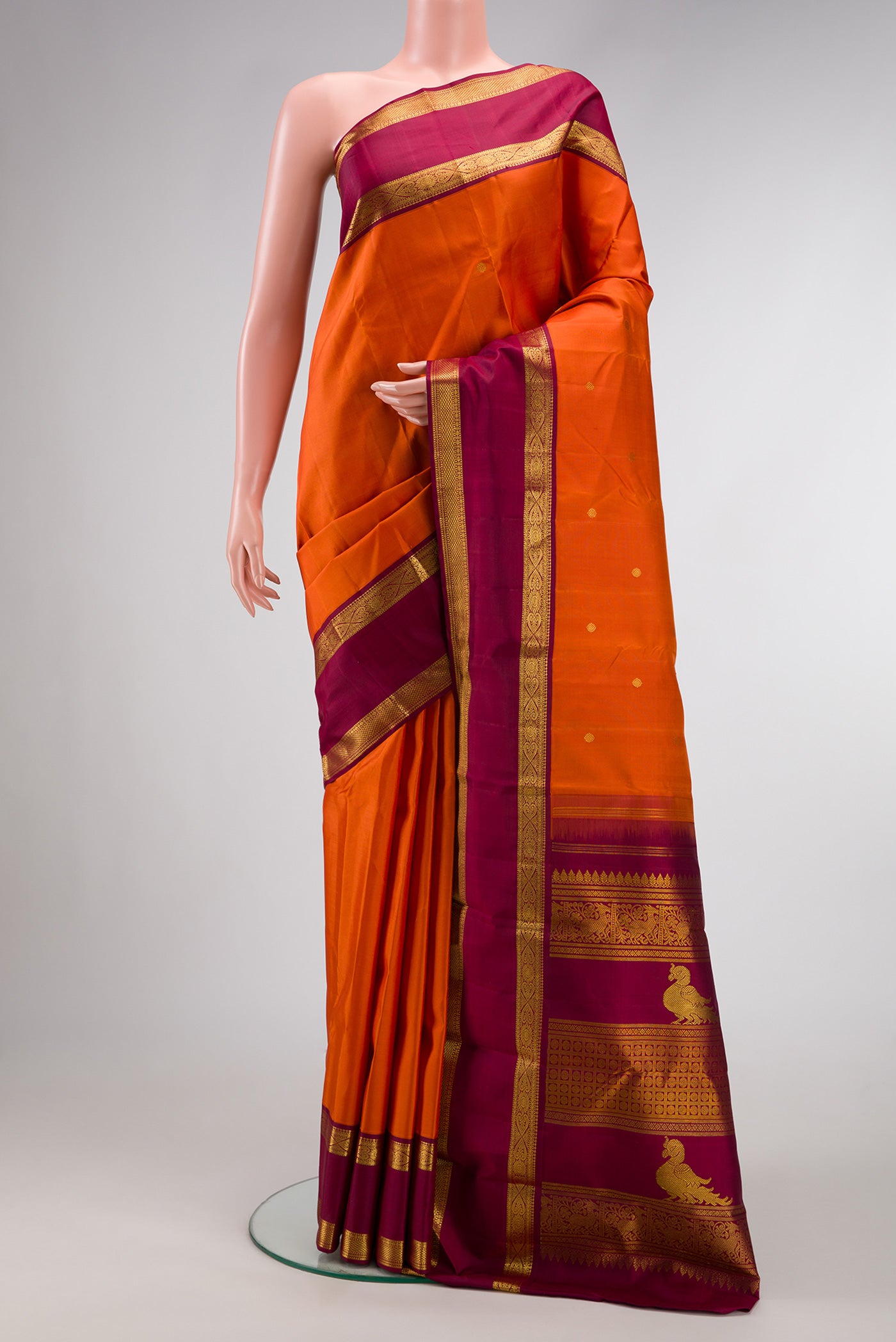 Pure Silk Pure Zari Brick Orange Dual Tone Kanjivaram Saree with Zari Butta on the body and Zari Border.  displayed on a mannequin